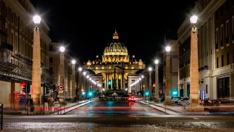 Stunning nighttime view of illuminated St. Peter's Basilica from Castel Sant'Angelo, captured on our scooter-guided tour.