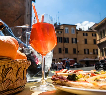 Aperitivo and pizza served outdoors in a Roman piazza under the sun